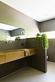 Modern gefliestes Bad mit elegantem Holzwaschtisch und Sichtschutzwand zum Toilettenbereich