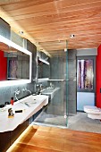 Modern bathroom with washstand, back-lit mirror, walk-in shower and toilet