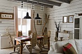 Gebogene Designerstühle mit Geflecht um gedeckten Esstisch in Zimmerecke mit weisser Holzverschalung an Wand