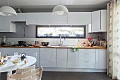 White fitted kitchen with ribbon window