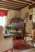 Antique chairs and sofa in renovated country house with rustic wood-beamed ceiling