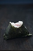 An onigiri sushi with a bite taken out