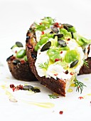 Bruschetta topped with ricotta, broad beans and pumpkin seeds