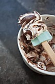 Schokoladen- und Vanille-Frosting in Rührschüssel vermischen