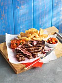 Grilled beef steak with chips and tomatoes