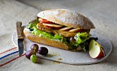 A fruity sandwich with turkey escalope, apple slices and grapes