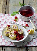 Pancake rolls filled with cream cheese and raspberries served with raspberry compote
