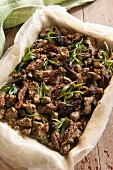 A half-finished duck and morel mushroom pie with tarragon
