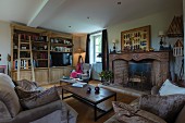 Sofas and coffee table in front of traditional open fireplace in rustic living room