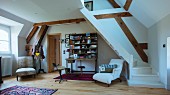 Pleasant interior in double-height attic room with winding wooden staircase painted white