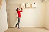 Woman holding box next to storage boxes hung on wall