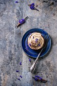 Schokoladencupcake mit Kaffee-Buttercreme und Lavendelblüten auf blauem Teller