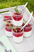 Glasses with rosemary cream cheese and raspberry and rhubarb compote on a tray in a garden