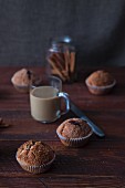 Homemade cinnamon muffins, a cafe latte and cinnamon sticks