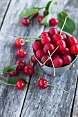 Fresh cherries in a metal bowl on a wooden surface