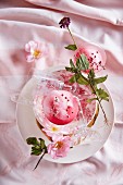 Champagner mit Rosensirup, Eiswürfeln und rosa Pfeffer