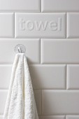 Towel hanging from suction cup hook on tiled wall