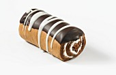 A chocolate Swiss roll with cream and icing sugar