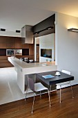 L-shaped kitchen counters with breakfast bar and integrated table for two; fitted cupboards with dark wooden fronts in background