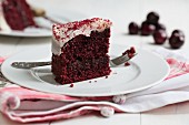 A slice of Red Velvet cake on a plate with a fork