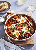 Baked eggs and lamb sausage in an oven dish