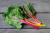 Swiss chard with stalks of various colours on wooden surface
