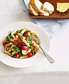 Summer pasta salad with cherry tomatoes, olives, bocconicini and rocket salad