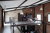 Gallery with stainless steel and wire rope balustrade in loft apartment with brick and stone walls