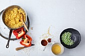 Vegetarian millet risotto with peppers, peas and ajvar being made