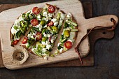 Vegetarian tortilla pizza with green asparagus, broccoli and tomatoes