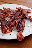 Knusprig gebratene Baconstreifen auf Teller