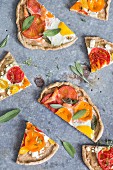 Pieces of wholemeal pizza with tomatoes, egg and sage