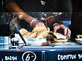 A cheeseburger being prepared in a food truck