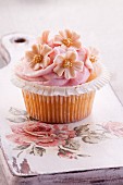 A cupcake with strawberry mousse and sugar flowers