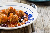 Vegan tofu balls in tomato sauce with capers and black olives