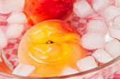 Scalded peaches being quenched in ice cold water