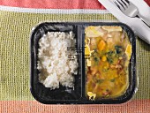 Pre-cooked and frozen chicken curry as a ready meal in a segregated plastic package