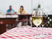 Weißwein und Rotwein aus Südafrika in Gläsern auf Restauranttisch