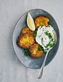 Corn cakes with herb cream and lemon wedges