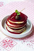 A stack of apple and beetroot slices with balsamic vinegar and mint