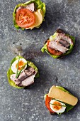 Open sandwiches with cheese, meat, eggs and tomatoes