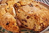Loaf of Irish Soda Bread with Slice Removed; Slice in Background on a Plate; Butter