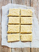 Vegan coconut slices on a piece of baking paper (seen from above)
