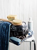 Handtücher in Blautönen, Seife und Körperbürste auf Spa-Hocker