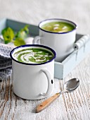 Cream of pea soup with mint in enamel mugs