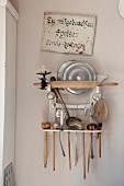 Vintage kitchen utensils on rack on wall painted pastel pink