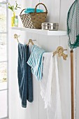 Selbstgemachter Handtuchhalter aus Seilen in hellem holzverkleidetem weißem Badezimmer