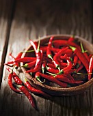 Bright red chilli peppers in a wooden bowl