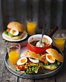 Bread rolls with a spicy bean sauce, eggs, rocket and tomatoes for brunch