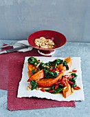 Pumpkin wedges on wilted spinach with goji berries